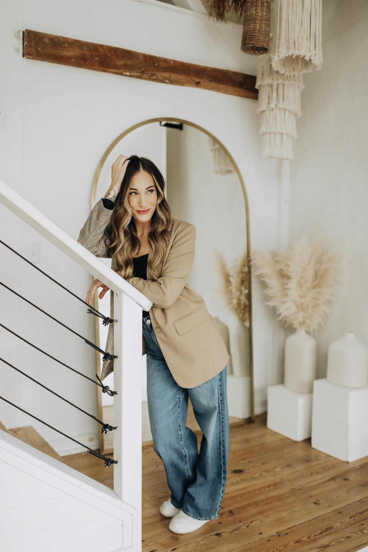 VABARE Skin founder Jillian Schaeffer standing on a staircase in a stylish interior setting