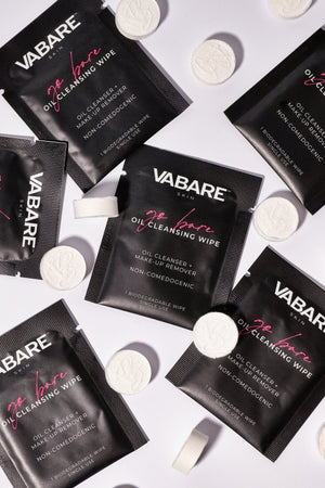 VABARE Go Bare Cleansing Wipes and Show Off Compressed Towels scattered on a white background