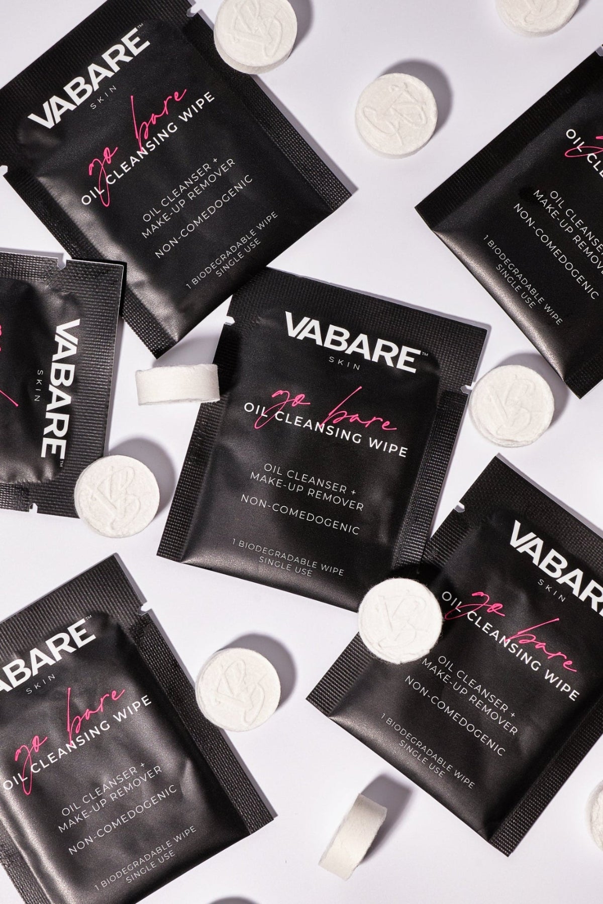 VABARE Go Bare Cleansing Wipes and Show Off Compressed Towels scattered on a white background