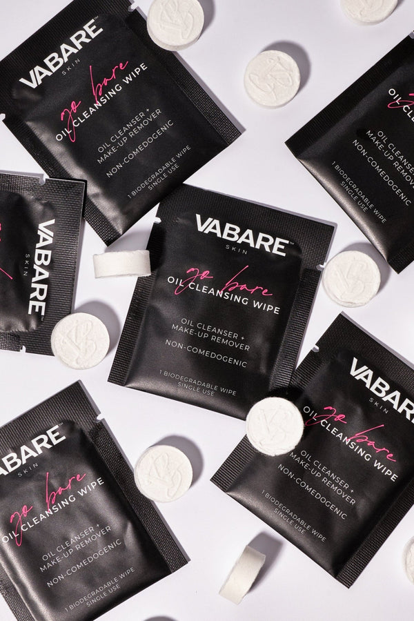 VABARE Go Bare Cleansing Wipes and Show Off Compressed Towels scattered on a white background
