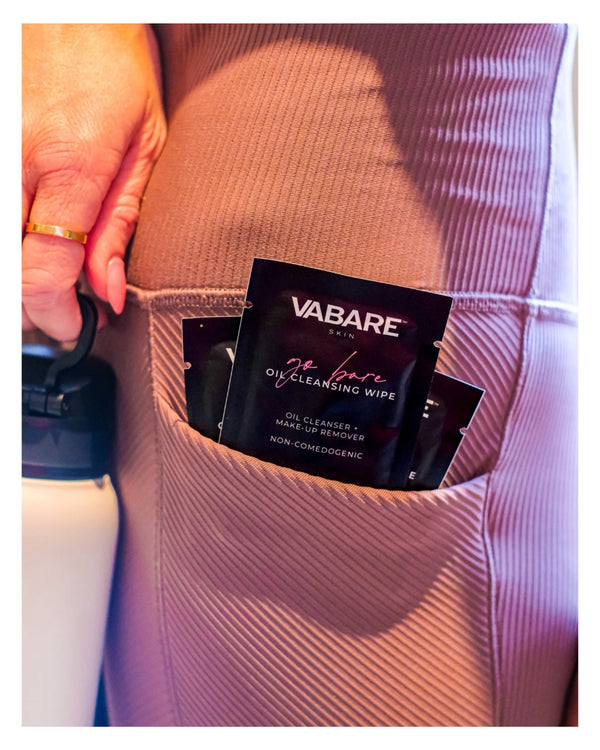 VABARE oil cleansing wipes in a pocket with a hand holding a bottle.