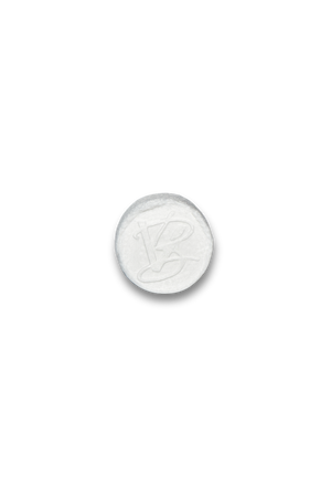 Front of a white compressed facial towel with VABARE logo on the surface